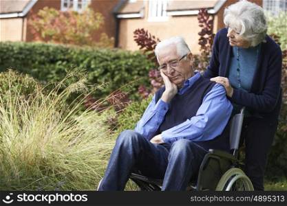 Depressed Depressed Senior Man In Wheelchair Being Pushed By Wife
