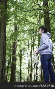 Depressed Man Contemplating Suicide By Hanging In Forest