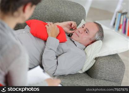 depressed man lying on couch and talking to therapist
