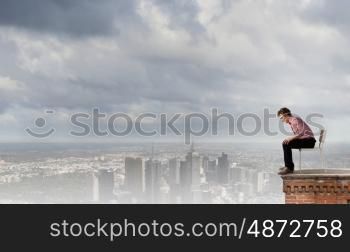 Depressed man sitting on a chair all alone. Being in despair