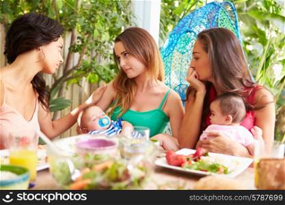 Depressed Mother With Baby Talking To Friends