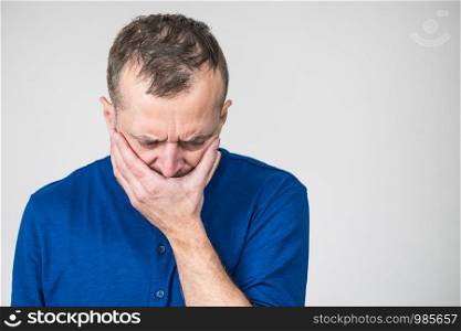Depressed, sad, worried adult man covering his mouth feeling guilt and shame.. Sad worried man covering his mouth