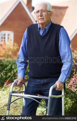 Depressed Senior Man Using Walking Frame Outdoors