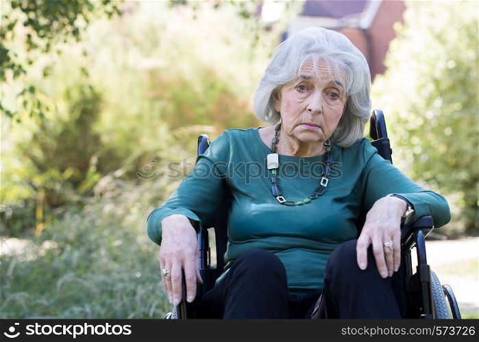 Depressed Senior Woman In Wheelchair Sitting Outdoors