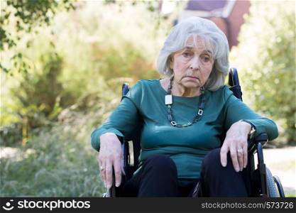 Depressed Senior Woman In Wheelchair Sitting Outdoors