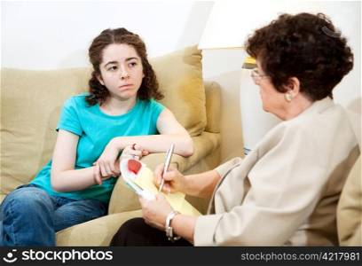 Depressed teen girl consulting with a psychologist.