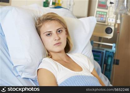 Depressed Teenage Female Patient Lying In Hospital Bed