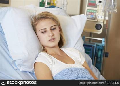 Depressed Teenage Female Patient Lying In Hospital Bed