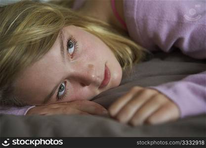 Depressed Teenage Girl Lying In Bedroom