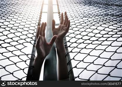 Depressed, trouble, help and chance. Hopeless women raise hand o. Depressed, trouble, help and chance. Hopeless women raise hand over chain-link fence ask for help