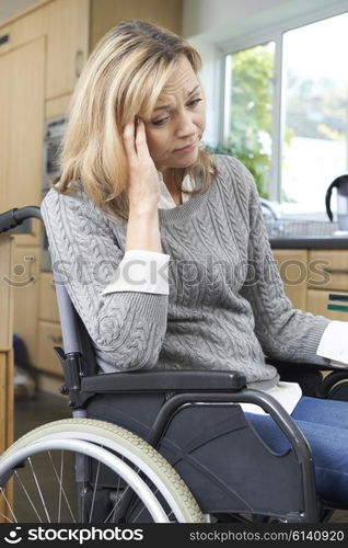 Depressed Woman Sitting In Wheelchair At Home