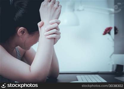 depressed women sitting in front computer after hard working alo. depressed women sitting in front computer after hard working alone sadness emotional and wrist arm pain. office syndrome healthcare and medicine concept