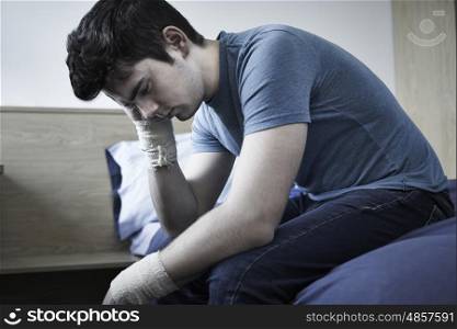 Depressed Young Man With Bandaged Wrists After Suicide Attempt