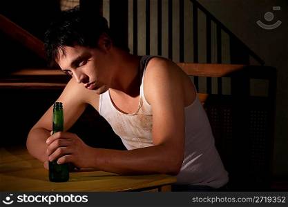 Depressed young man with beer bottle