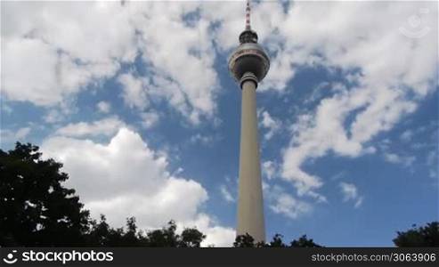 Der Berliner Fernsehturm im ostlichen Zentrum von Berlin am Alexanderplatz mit schenll vorbeiwehenden Wolken via Zeitraffer bzw. Time Lapse