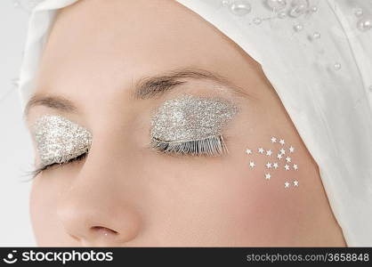 desaturated close up on eyes with silver make up and silver eyelashes