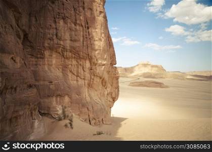 Desert landscape with blue sky and sun with sand and mountains