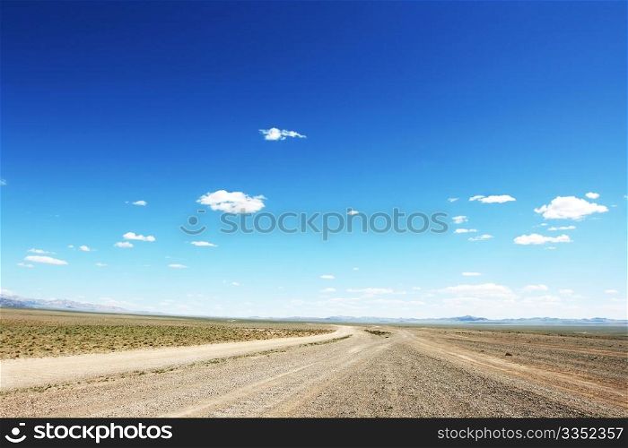 Desert road in Mongolia with dramatic sky