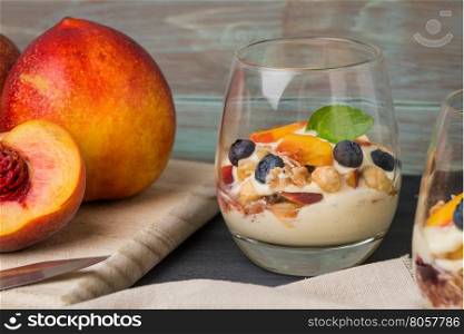 Desert with whipped cream and peach on wooden table.
