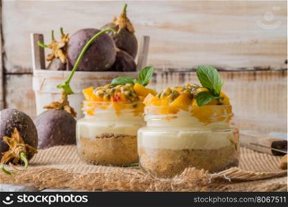Desert with yogurt and passion fruit top on wooden table.