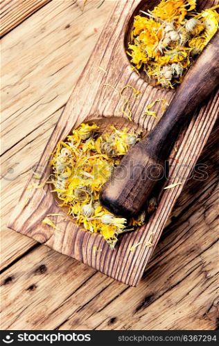 desiccated medicinal herbs. wooden mortar with medicinal herbs and plants