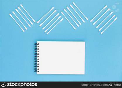 design made with cotton swabs blank spiral notepad blue background