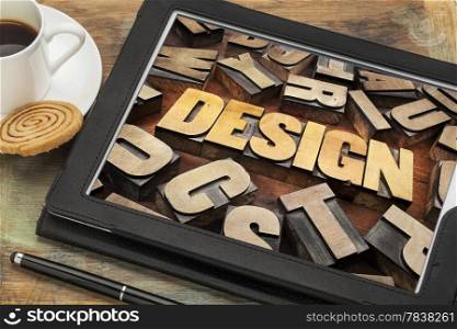 design word abstract in letterpress wood type on a digital tablet with cup of coffee