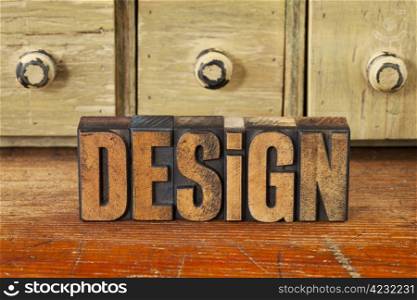 design word in vintage wood letterpress printing blocks with rustic drawer cabinet in background