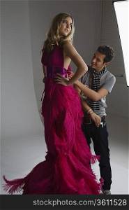 Designer Adjusting Dress Back on Fashion Model