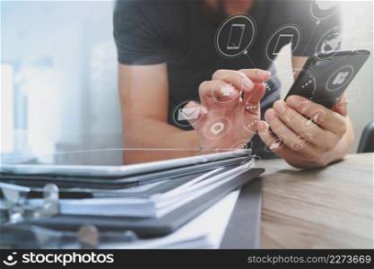 Designer hand using mobile payments online shopping,omni channel,in modern office wooden desk,icons graphic interface screen,eyeglass,filter