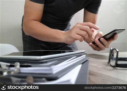 Designer hand using mobile payments online shopping,omni channel,in modern office wooden desk,icons graphic interface screen,eyeglass