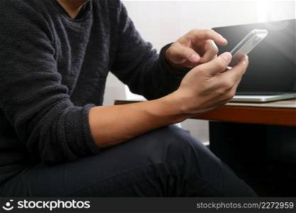Designer hand using mobile payments online shopping,omni channel,laptop computer on wooden desk in modern office