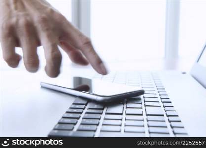 designer hand working and digital tablet and laptop on wooden desk in office
