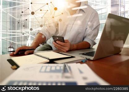 designer hand working and smart phone and laptop on wooden desk in office with london city background with social media diagram              