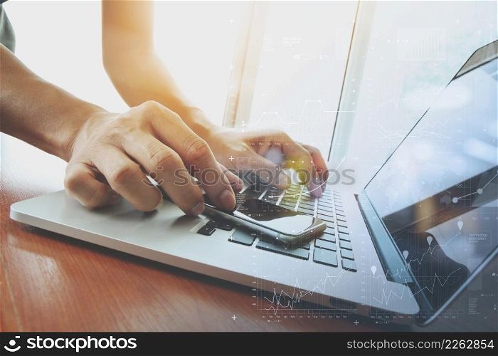 designer hand working and smart phone and laptop with digital business strategy layer effects on wooden desk in office