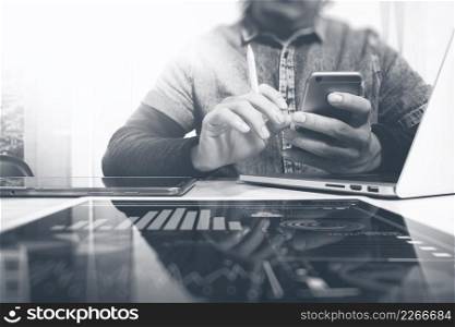 Designer hand working in creative studio. Using modern laptop digital tablet smart phone.responsive design website. Blurred background sun flare effect,horizontal mock up photo, black white