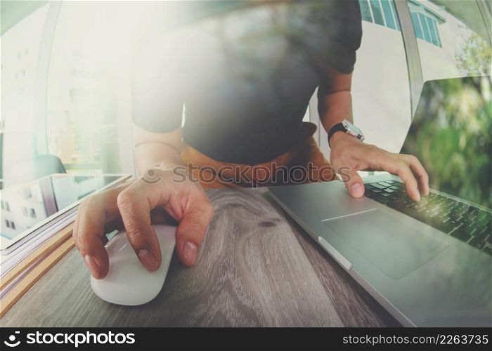 Designer hand working with laptop computer on wooden desk as responsive web design concept