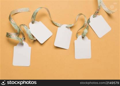 designer ribbon through empty labels arranged bright yellow surface