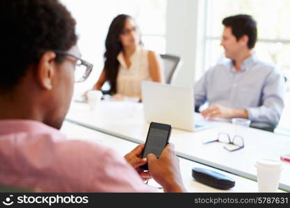 Designer Using Mobile Phone During Meeting