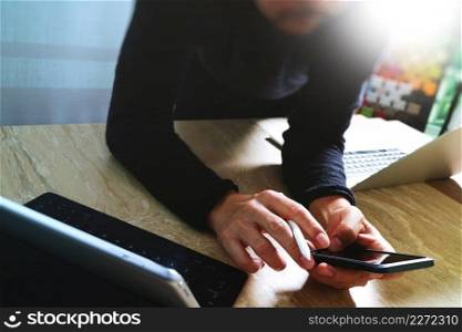 designer using smart phone and keyboard dock digital tablet with laptop computer.Worldwide network connection technology interface.on marble desk,sun flare effect