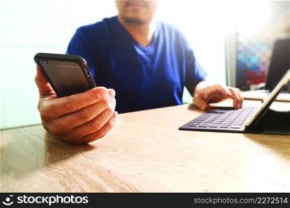 designer using smart phone and keyboard dock digital tablet.Worldwide network connection technology interface.on marble desk,sun flare effect