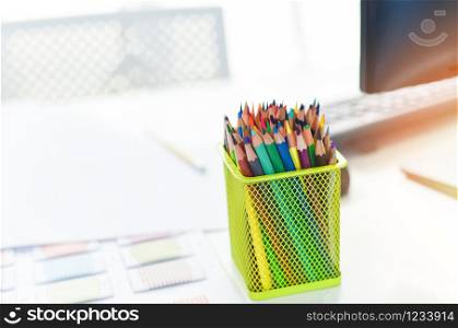 Desk in office with computer and Color pencils or Crayons colored for designer desk / Table working place business office background