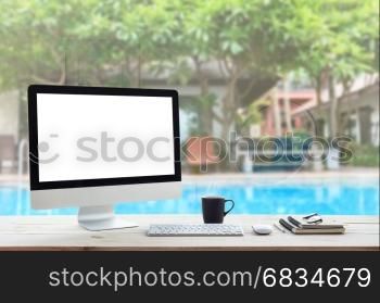 desktop computer on work table and see through resort hotel background