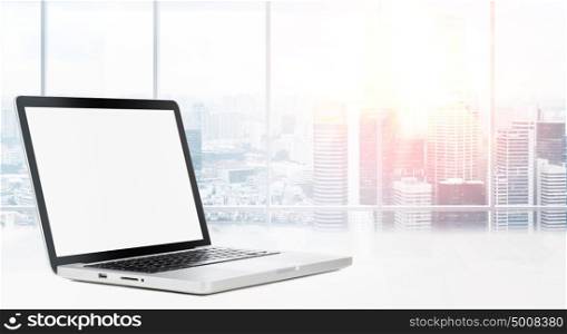 Desktop with panoramic view. Laptop on table in office with panoramic view of modern downtown skyscrapers at business district