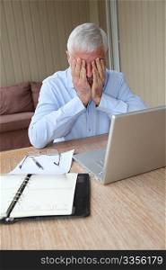 Desperate senior man in front of laptop computer
