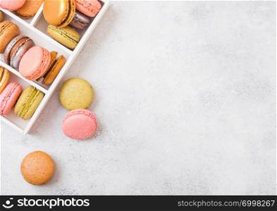 Dessert cake macaron or macaroon in white wooden boon stone kitchen background . Top view. Space for text.