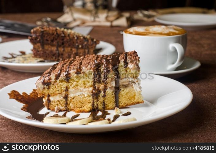 Dessert cakes with banana and coffee at table