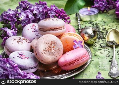 dessert of french macaroons. macarons cake and branch of springtime lilac blossoms