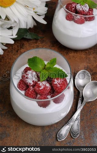 Dessert of whipped cream with raspberries and mint in a glass