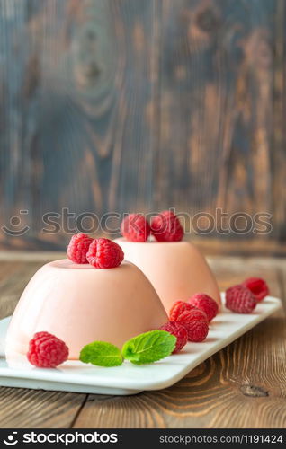 Dessert puddings decorated with fresh raspberries and mint leaves